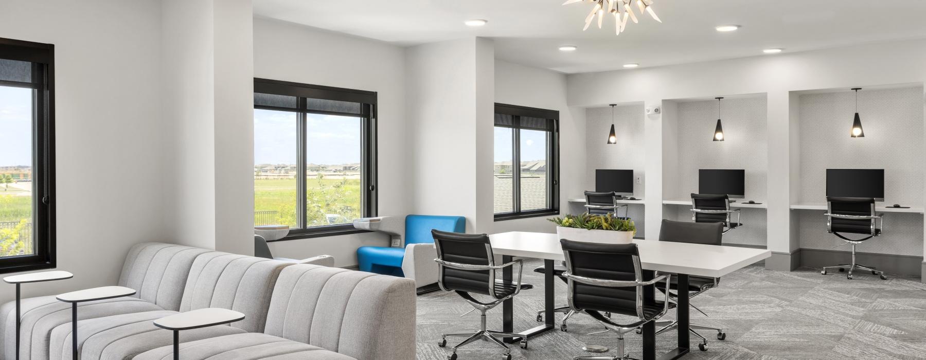 room with large windows and computers at desks