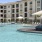 a pool with umbrellas and chairs by a building