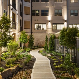 Find your perfect fit at Brea Luxury Apartments a courtyard with trees and plants in front of a building
